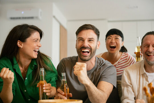 Friends celebrating football victory watching world cup at home