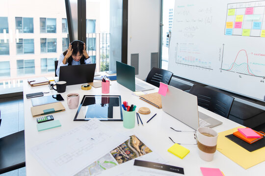 Female manager experiencing work stress and anxiety in modern office