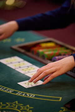 Female Dealer Revealing Cards at Casino Blackjack Table