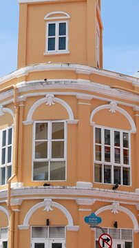 Vertical View of Historic Yellow Clock Tower and Passing Traffic