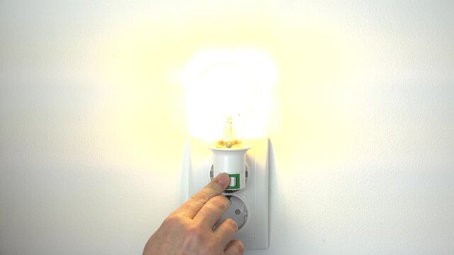 Turn On the Light in a Dark Room, Turning the Light On a Led Bulb, Girl Turns the Light Off at Home, Pull Switch On Off, Electricity Concept, Global Crises