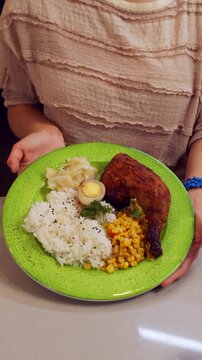 Close-up of a Person Holding a Plate with Delicious Food