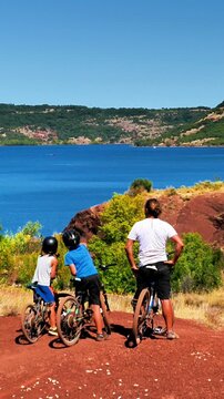 family on bike, father and children on mountain bike enjoying beautiful landscape of lake, France, Salagou