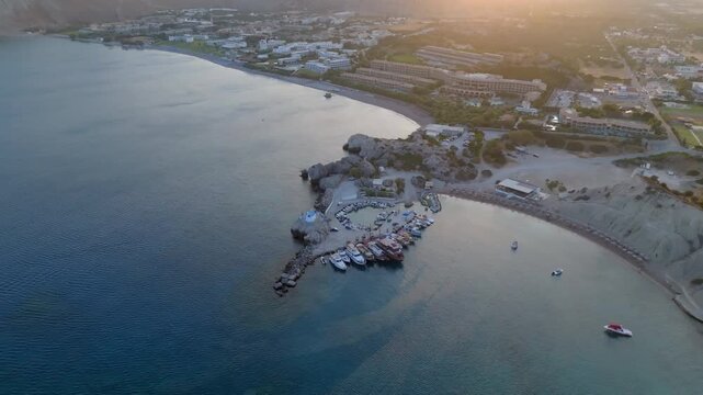 High angle drone shot circling Kolymbia town harbor, sunny evening in Greece