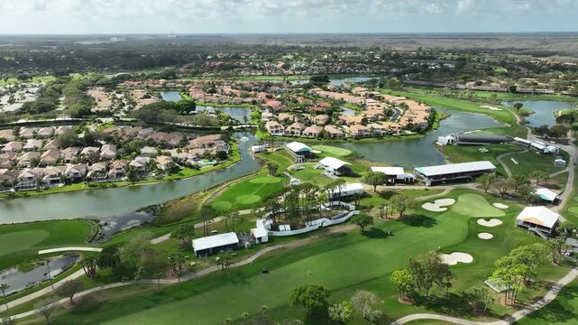A high-altitude aerial view captures the vibrant greens and lakes surrounding PGA National Resort in Palm Beach Gardens.