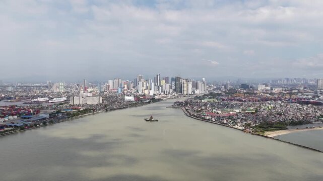 Vast aerial perspective of the pasig river flowing through the dense urban landscape of manila, philippines, with a tugboat navigating the murky waters towards the modern city skyline