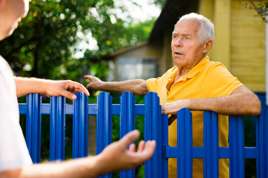 Farm neighbors talk at the border of garden plot