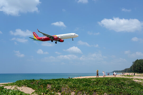 Airbus a321 Vietjet airways landing above beautiful beach with people on the beach and sea, travel. Thailand, Phuket International airport. 09 March 2026.