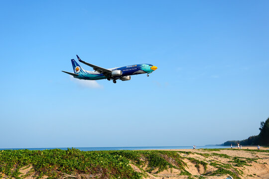 NokAir airways bird boeing 737-800 landing above beautiful beach with people on the beach and sea, travel. Thailand, Phuket International airport. 10 March 2026.