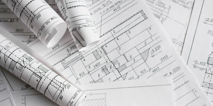 Blueprints, rolled plans and drafting tools on desk, architectural engineering workflow concept for construction planning, technical documentation, project management and building design.