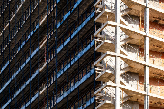 Bright urban construction facade with brick concrete scaffold glass contrast showing architecture and development progress in spain with daylight detail