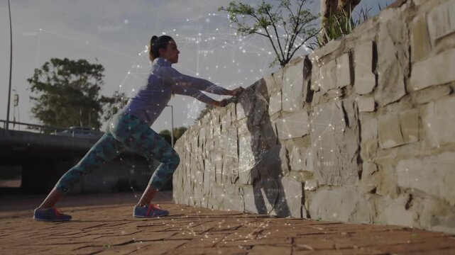 Woman placing hands on wall and stepping back, pushing up and driving knee inward for fitness