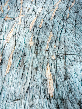 Aerial view of the Rhone Glacier's icy expanse, with its intricate patterns of cracks and crevasses revealing the glacier's ancient secrets, Obergoms, Valais, Switzerland.