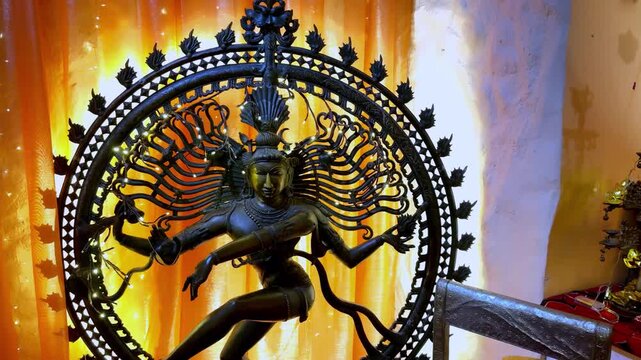 Ancient Bronze Nataraja Statue of Lord Shiva performing Tandava dance in sacred temple during golden hour summer sunset with warm orange lighting and cinematic eye level medium shot for spirituality