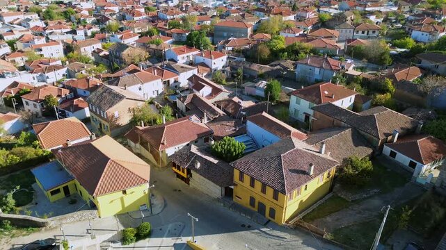 Cinematic top-down drone shot of the Silk Museum and a traditional square in Soufli, Greece. High-angle view of neoclassical architecture and red tiled roofs. Perfect for cultural travel films.