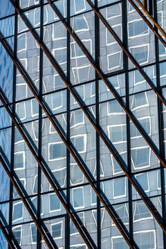 Diagonal grid of modern glass windows on a corporate facade creating precise geometry and abstract architectural pattern suited for business design backgrounds