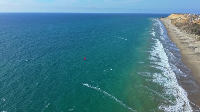 Drone view of kitesurfers riding wind along Santa Marianita coastline near Manta, Ecuador.
