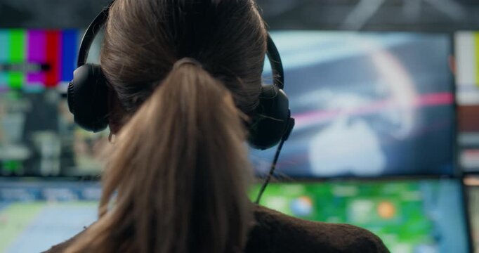 Backstage at a TV Station Production Control Room: Portrait of Female Director Producer Wearing a Headset Monitors Live Channel Feeds, Weather, Sports, Entertainment, Using Studio Screens News Broadca