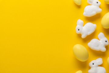 Happy Easter holiday background. Yellow Easter egg decoration, white Easter bunny on yellow...