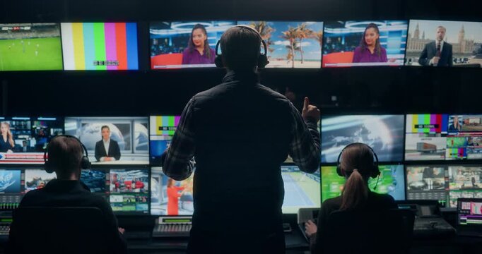 Backstage TV Station Production Control: Producer Directing Technicians and Operators to Switch Between Programs Live News Broadcasting, Anchor, Sport, Weather, Entertainment Channel Feeds on Monitors