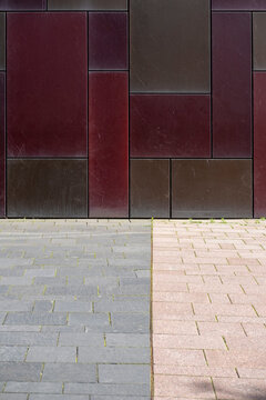 Modern urban facade with panels and tiles above pavement showing minimal geometry pattern texture and clean copy space for background layout template