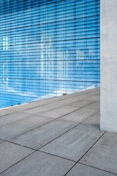 Modern blue glass facade with reflections and clean lines creating minimal urban architecture background with copy space for business design template