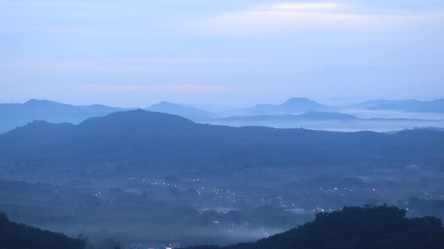 Natural video background of a high-angle atmosphere on a mountain that overlooks the surrounding scenery(mountains, trees,sea)from a scenic vantage point,with a wooden chair for sitting and resting