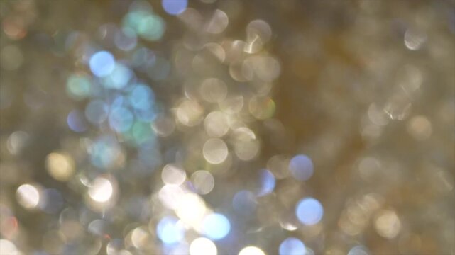 Golden bokeh lights with blurred circular highlights and warm tone creating an abstract light pattern suitable for luxury background use.