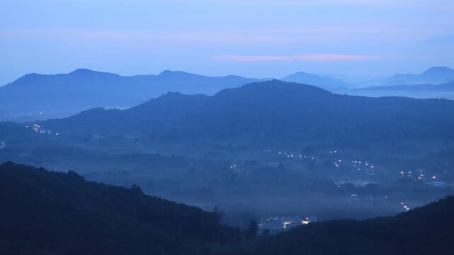 Natural video background of a high-angle atmosphere on a mountain that overlooks the surrounding scenery(mountains, trees,sea)from a scenic vantage point,with a wooden chair for sitting and resting
