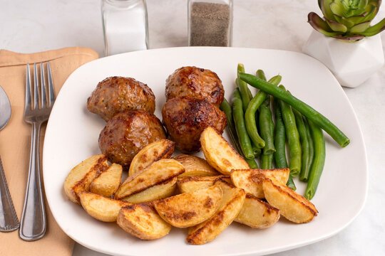  meat balls and  green beans and potoe wedges