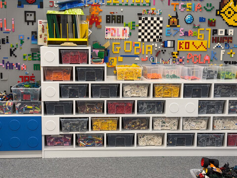 Organized lego storage wall with colorful pixel-art background