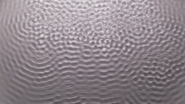 Abstract pattern of water surface ripples created by sound waves