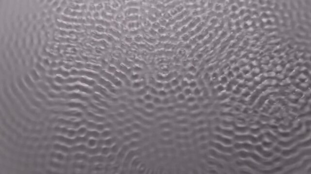 Abstract patterns of water surface ripples created by sound waves in cymatics experiment