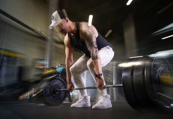 Naklejka premium Fitness and health concept. A fit young man works out in a modern gym. Athletic man doing exercise.