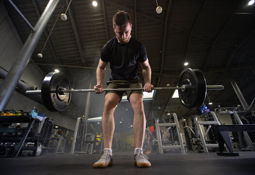 Fitness and health concept. A fit young man works out in a modern gym. Athletic man doing exercise.