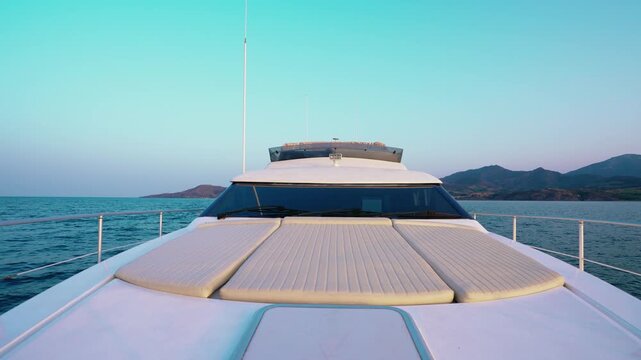 Relaxation Area on Luxury Yacht Bow with Scenic Coastal Mountains at Dusk