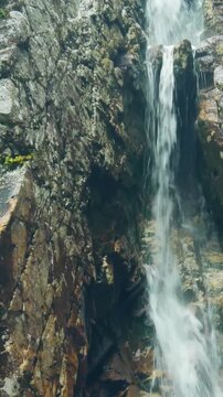 Vertical Waterfall Cascading Down Rocky Cliff