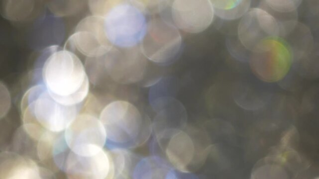 Cool toned bokeh lights with soft blur and scattered highlights forming an abstract lighting pattern that creates a calm winter mood for seasonal design use.