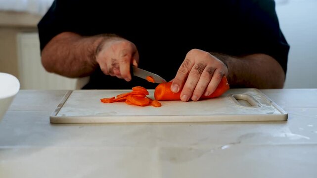 Slicing carrots on a kitchen counter during meal prep time in the afternoon