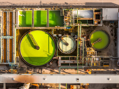 Aerial view of vibrant green and pale tanks juxtapose against the stark industrial architecture, creating a striking visual symphony, Atessa, Abruzzo, Italy.