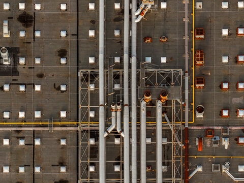 Aerial view of a rooftop with a complex network of pipes and vents creating a stark geometric pattern against the flat surface, Atessa, Abruzzo, Italy.