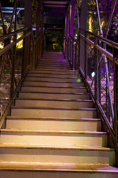 The stairs leading up to the pedestrian bridge, night in the city.