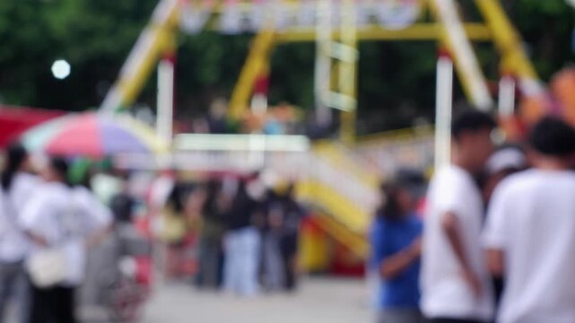 Residents from neighboring towns enjoy the amusement rides at the government-sponsored trade fair held in the public grounds. Blurs