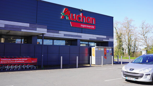 MARINGUES, FRANCE - MARCH 18, 2026: Auchan supermarket entrance with parcel lockers and car.
