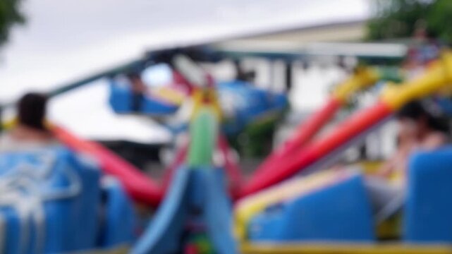 Residents from neighboring towns enjoy the amusement rides at the government-sponsored trade fair held in the public grounds. Blurs