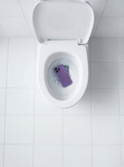 Fototapeta premium Modern smartphone dropped down toilet
