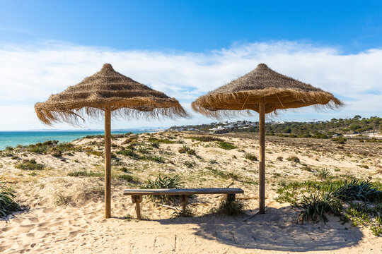 Straw Umbrellas on Sandy Beach in Quinta do Lago, Algarve, Portugal