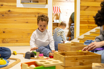 Children playing with wooden toys in nursery school