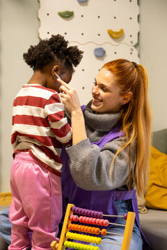 Teacher caring for african american girl in nursery school