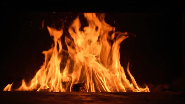 Flames rising high in darkness.